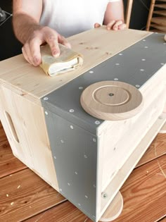 a man is working on a project with wooden blocks and plywood pieces, including a piece of wood that has been glued to it