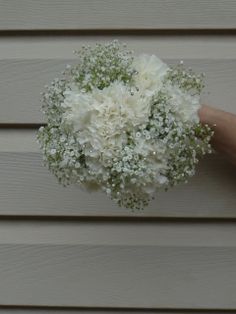 a bouquet of white flowers sitting on top of a wooden table