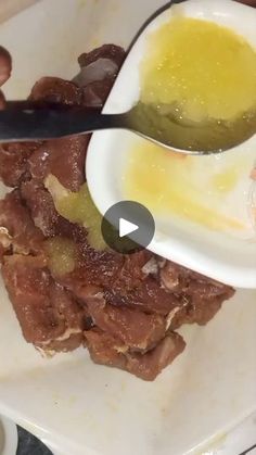 a person is spooning some food out of a white bowl on top of a plate