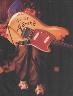 a person holding a guitar with writing on it