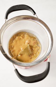 a strainer filled with food on top of a white counter