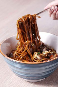 someone is eating noodles with chopsticks in a bowl