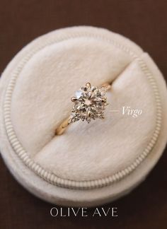 an engagement ring in a box with the word virgo written below it on top