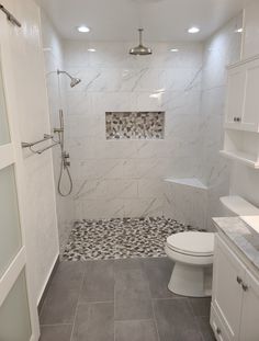 a bathroom with a toilet, sink and shower stall is shown in this image from the front view