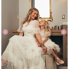 mother and daughter sitting on stool in front of mirror