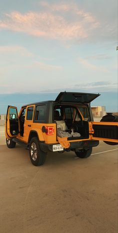 a yellow jeep with its hood open parked on the side of an airport tarmac