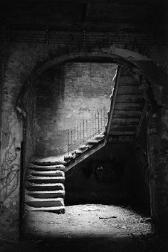 an old stairway with graffiti on the walls and steps leading up to it in black and white