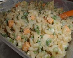 a plastic container filled with macaroni salad and carrots on top of a table