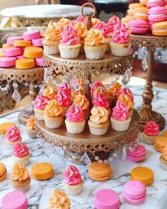 three tiered tray with cupcakes and other desserts on top of it