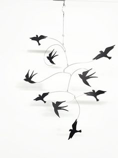 several birds are flying in the air with wires attached to them and one bird is black