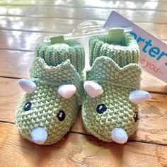 a pair of green crocheted slippers sitting on top of a wooden floor