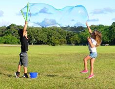 two children playing with bubbles in a field