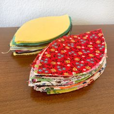 several pieces of fabric sitting on top of a wooden table