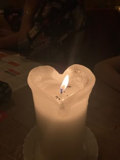 a white candle with a heart shaped candle holder in the shape of an ice cube