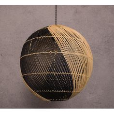 a black and white ball hanging from a string on a wall next to a gray wall