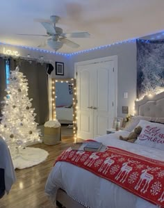 a bedroom decorated for christmas with lights on the ceiling and a tree in the corner