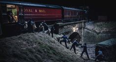 several people are walking up the side of a train track at night, with one person holding onto another man's hand