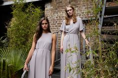 two women standing next to each other in long dresses