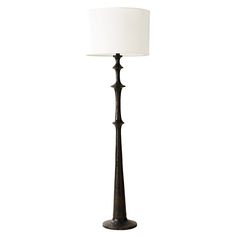 a floor lamp with a white shade on the top and bottom part of it's base