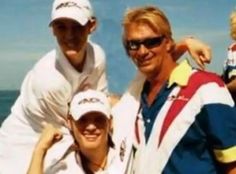 two men and a woman standing next to each other in front of the ocean on a sunny day