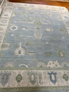 a blue and green rug sitting on top of a wooden floor next to a window