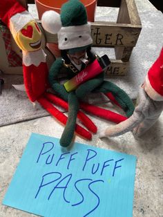 a stuffed animal sitting on top of a table next to a sign that says puff puff pass