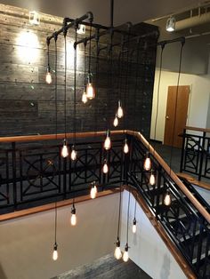 the lights are hanging from the railing in the building's lobby area, which is decorated with brick walls and wrought iron handrails