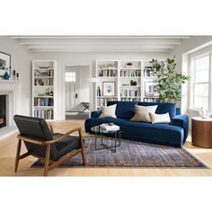 a living room filled with furniture and a fire place in front of a book shelf