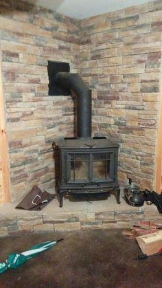 there is a wood stove in the corner of this room with tools on the floor