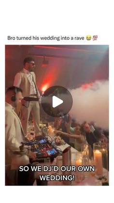 a man standing on top of a table in front of a crowd at a wedding