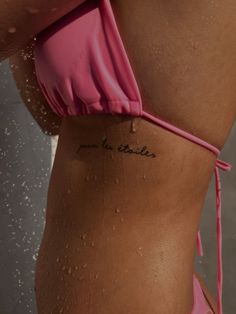 a woman's stomach with water drops all over it and the word love is written in cursive ink