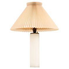 a white lamp with a beige shade on it's base and a black light bulb