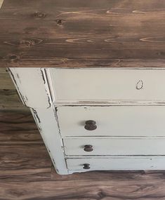 an old white dresser with some knobs on it