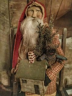 an old fashioned santa clause holding a christmas tree