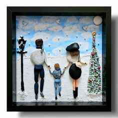 three people are holding hands in front of a christmas tree and street light with snow on the ground