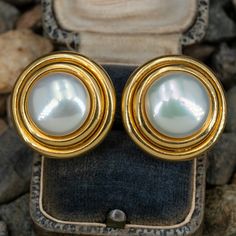 These wonderful vintage Gump's pierced earrings are each accented with one (1), post set, cultured Mabe' pearl. The earrings measure 22.7mm wide and are finished with omega style hinged backs. Signed Gump's. The earrings show a lovely soft patina. Luxury Vintage Earrings With Polished Finish, Classic Hinged Earrings For Formal Occasions, Classic Hinged Formal Earrings, Classic Formal Hinged Earrings, Classic Clip-on Pearl Earrings, Vintage Yellow Gold Clip-on Pearl Earrings, Classic Yellow Gold Clip-on Pearl Earrings, Timeless Round Clip-on Earrings For Formal Occasions, Classic Hinged Earrings For Anniversary