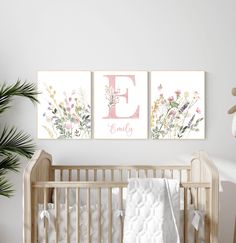 a baby crib with two paintings on the wall and a teddy bear next to it