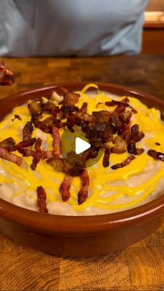 a wooden bowl filled with food on top of a table