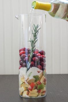 a vase filled with fruit and vegetables on top of a table