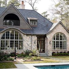 a stone house with arched windows and a pool