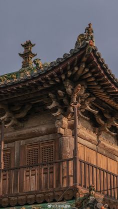 an old wooden building with ornate decorations on the roof