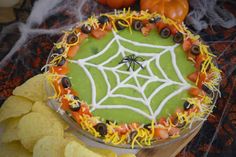 a halloween cake decorated with black and orange decorations on top of a wooden platter