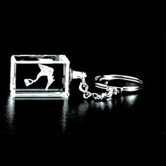 a keychain that has a glass block with a silhouette of a person on it