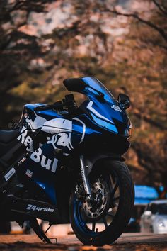 a blue motorcycle parked in front of some trees