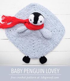 a crocheted penguin with a red scarf on it's head and eyes