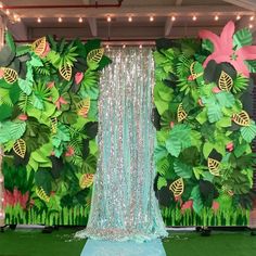 a stage set up for a party with green and pink decorations on the wall behind it