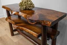 two wooden tables sitting on top of each other in a room with wood floors and white walls