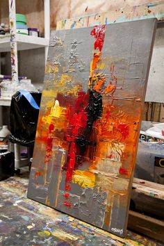 an abstract painting is being displayed in a studio