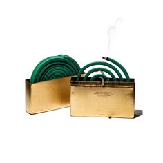 there are green hoses in a gold box on the table next to each other