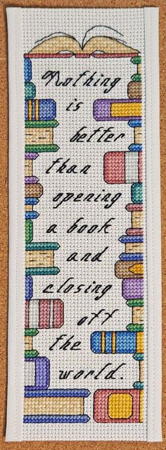 a cross stitch bookmark with books on it and the words written in cursive writing